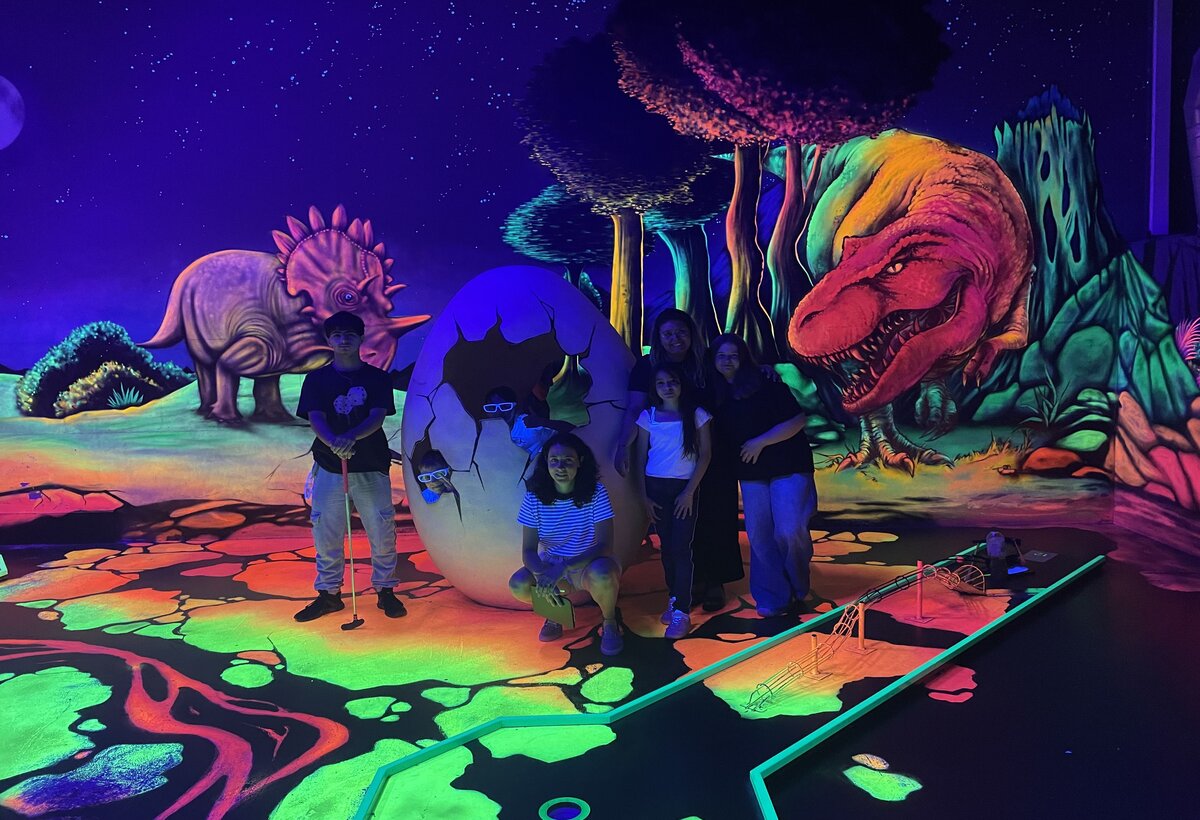 Jugendliche spielen Schwarzlichtminigolf