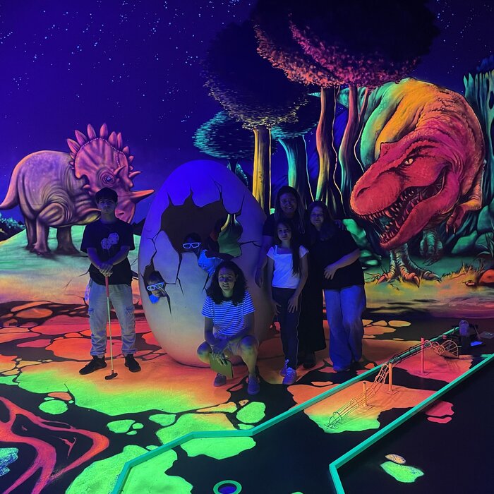 Jugendliche spielen Schwarzlichtminigolf