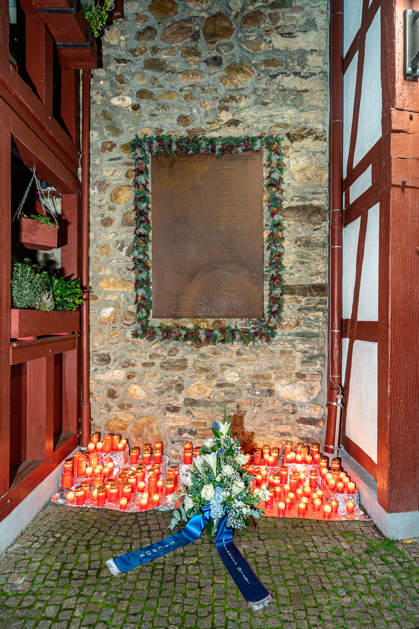Pogromgedenken, Kerzen und ein Kranz mit Schleife